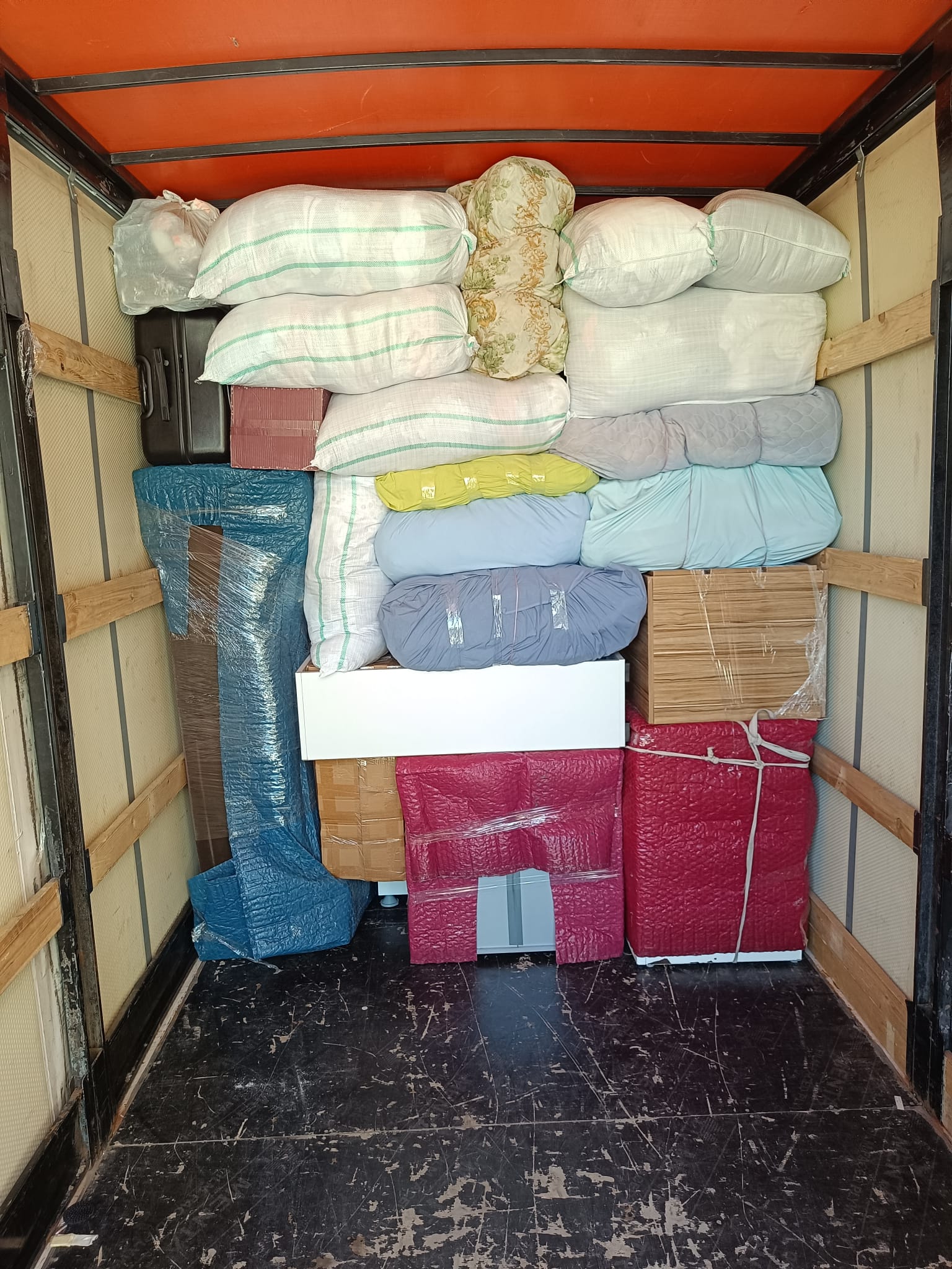 Kapalı kasa araçta düzenli biçimde istiflenen parça ev eşyaları
